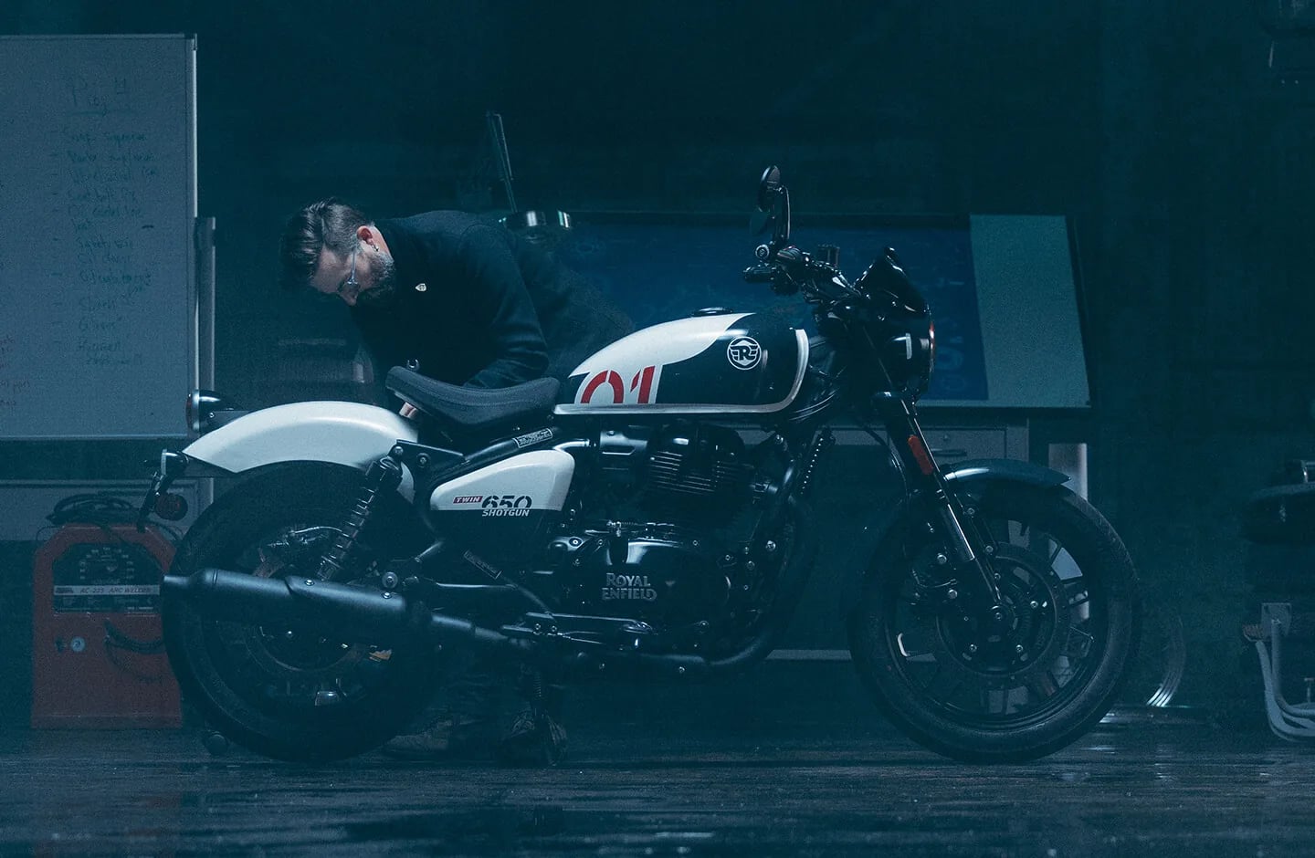 Механик обслуживает мотоцикл Royal Enfield в мастерской
